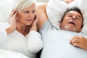 older man snoring in bed