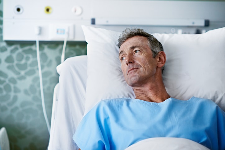 Older Man sitting in Hospital Bed Waiting for Surgery