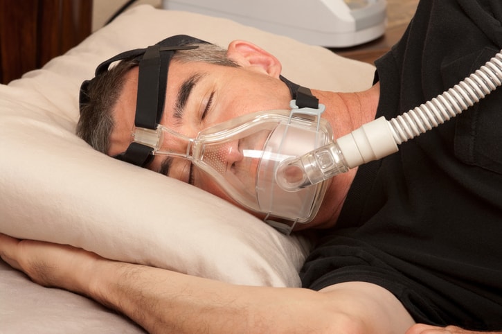 Man with Sleep Apnea sleeping with CPAP machine